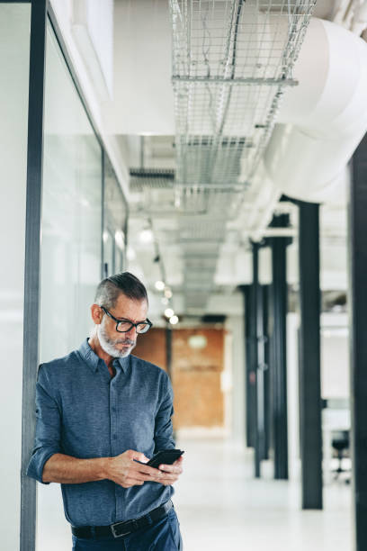 istock Mature businessman using a mobile phone in an office 1340512114