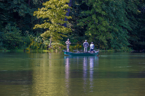 Elizabethton, Tennessee USA - August 21, 2021:  Fishermen fishing in the calm clear waters of the Watauga River.