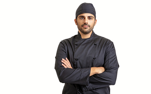 Chef cook in black uniform isolated on white background. Young handsome man with beard and cup standing with crossed hands
