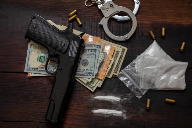 마약 밀��수 및 인신매매, 수갑, 권총 돈 및 코카인나무 테이블 배경 - gun possession 뉴스 사진 이미지