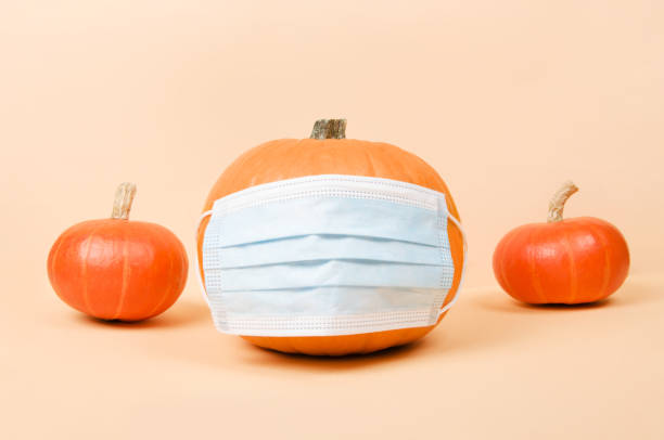 istock Orange pumpkin is wearing protective medical mask. 1340513846