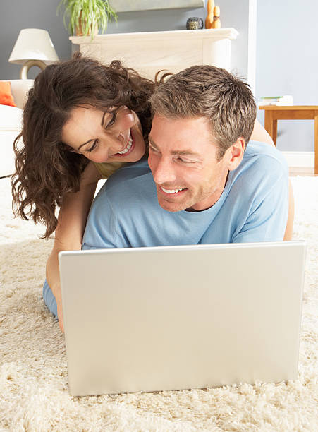 istock Couple Using Laptop Relaxing Laying On Rug At Home 134051666