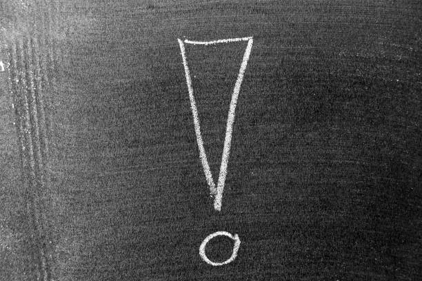 White color chalk hand drawing in exclamation mark with blank space shape on blackboard or chalkboard background