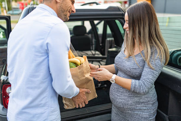 istock Young couple is packing groceries in car trunk 1340517085