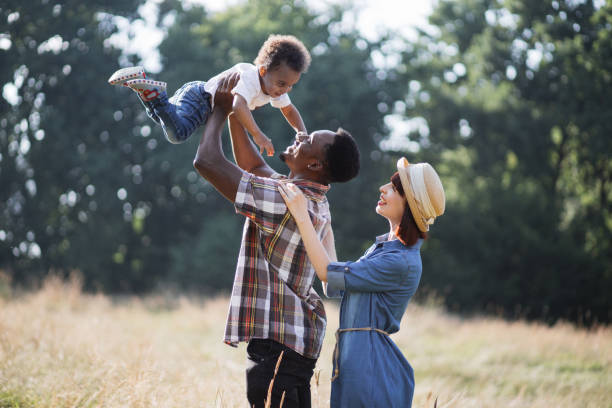 istock Multicultural parents playing with little son on nature 1340519557