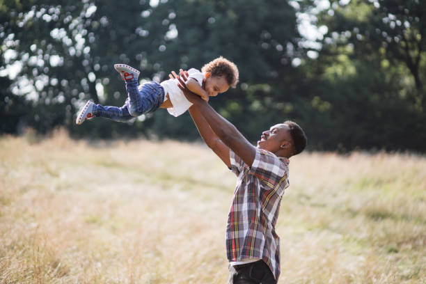 istock Cheerful father playing with little son on summer field 1340519803