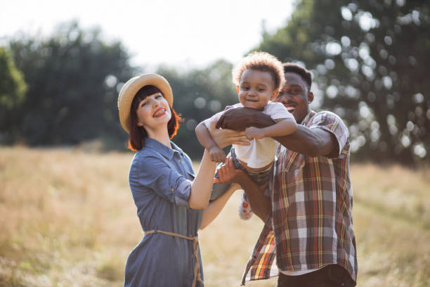 istock Beautiful multicultural parents playing with son on field 1340520015