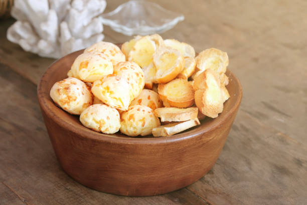cheese bread and toast served in wooden basket on table - brazilian food - selective focus