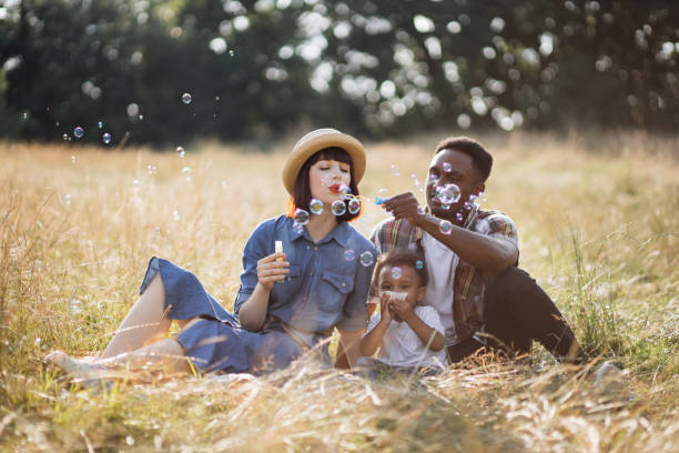 istock Mixed race family blowing soap bubbles on fresh air 1340520368
