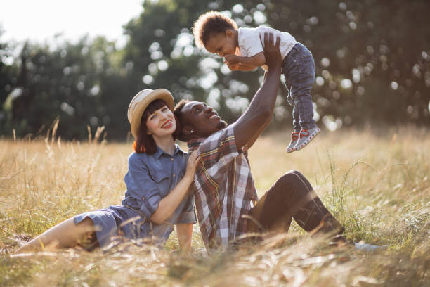 istock Cheerful diverse parents playing with little son on field 1340520392