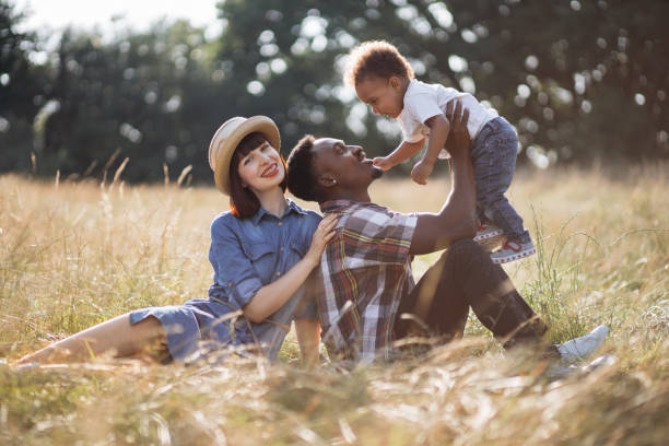 istock Happy multiracial parents playing with little son on field 1340520402