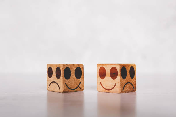 istock Facial on cube wooden block with emotion and expression about sincerity and frankness with metaphor on desk, symbol of positive with smile and happy concepts, negative or sham with unhappy. 1340521797