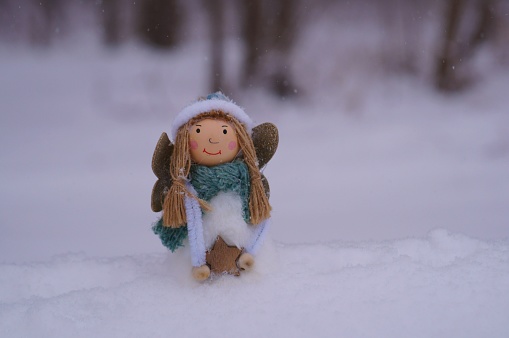 A toy angel on a snow background.