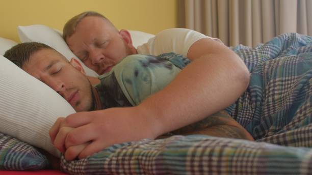 movimiento de cámara dos hombres homosexuales están durmiendo en la cama. un brazo abrazó al hombre. - couple love snoring sleeping fotografías e imágenes de stock