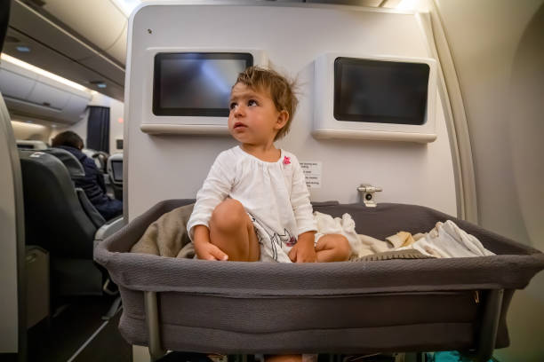 Baby Boy wake up afret sleeping In Bassinet On Airplane. first flight stock photo