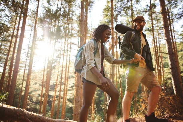 Forest walk and camping adventures Love couple hikers in the forest, walking and speaking for a good place for camping hiking stock pictures, royalty-free photos & images