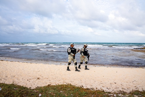 Tulum, Mexico. May 25, 2021. Two soldiers of Mexican army patrolling beach during coronavirus pandemic