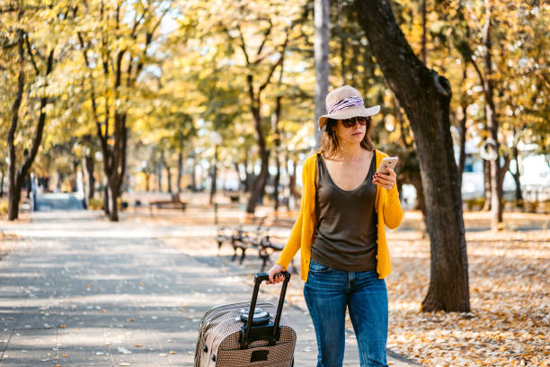 istock Tourist with suitcase walking through park 1340534255