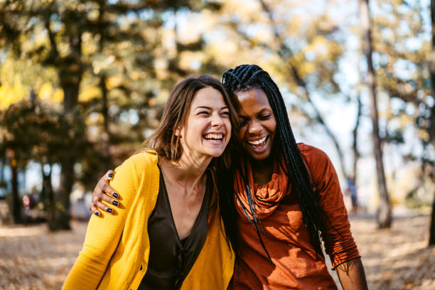 istock Multi-ethnic female friends embracing and laughing in park 1340534982
