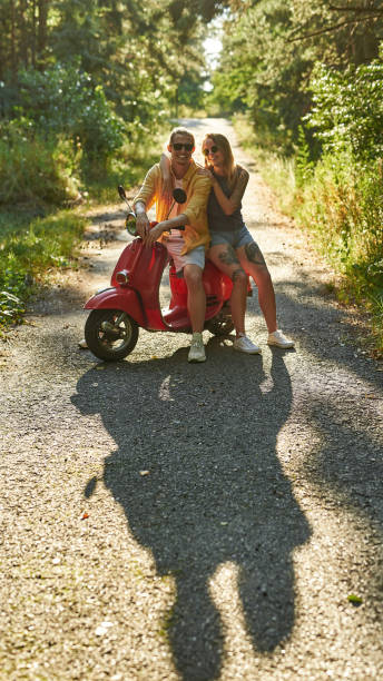 mignon jeune couple caucasien en scooter en bois - motorcycle motor scooter couple young adult photos et images de collection