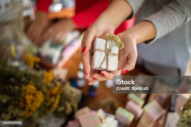 Young Woman Holding Packed Handmade Soaps From Natural Oils At Her Home Workshop Stock Photo - Download Image Now