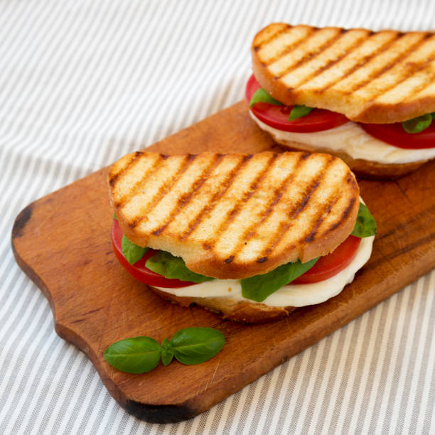 istock Tasty Grilled Caprese Panini (Mozzarella, Tomatoes and Basil) on a rustic wooden board, side view. 1340543765