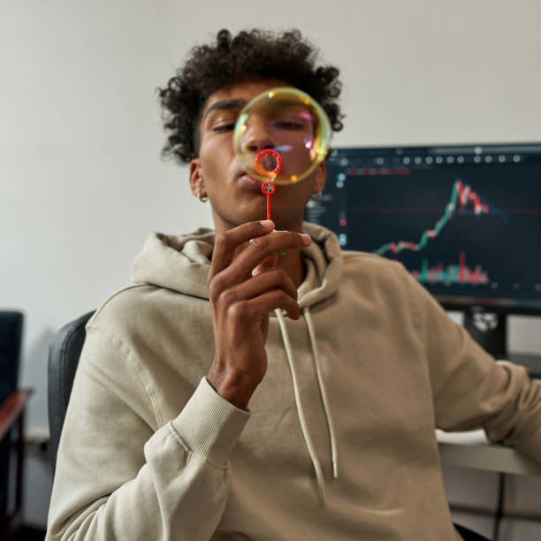 istock Ethnic male trader blow bubbles working on market 1340543856