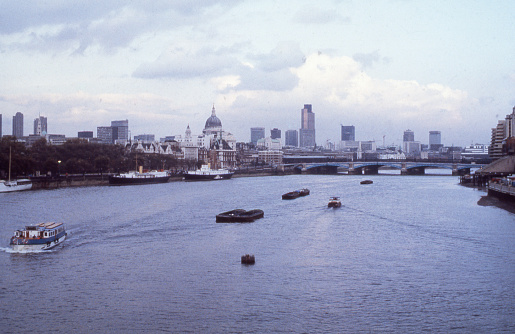 A partial view of the London Skyline facing eastward from the Waterloo Bridge highlights the importance of London's bustling river commerce. Figuring prominently among the numerous buildings is the dome of St. Paul's Cathedral, a popular tourist destination.