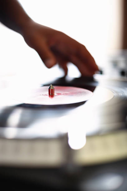 istock Turntable and dj hand on background. Disc jockey turn table player device with vinyl record disc 1340548622