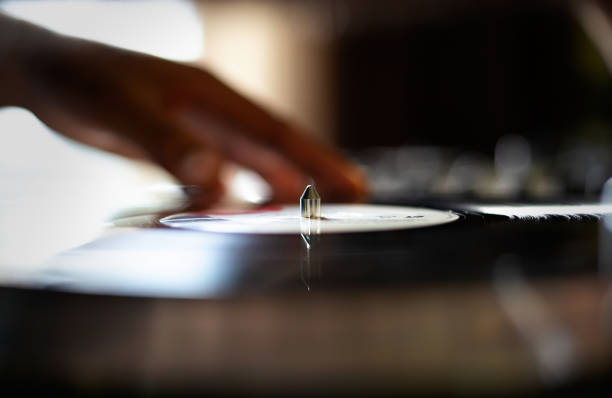 Professional hip hop dj plays music with retro style turntables and sound mixer devices on party or in sound recording studio