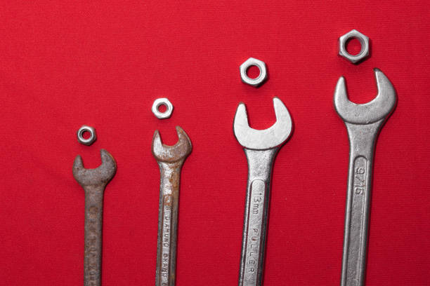 Wrenches, rusty, arranged in ascending order on a red background leaving space for advertising text. Construction tools