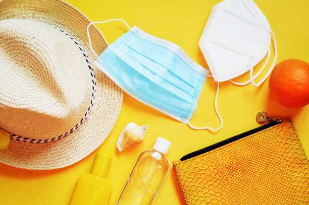 istock Summer travel 2021 during coronavirus pandemic, post lockdown vacations. Disposable mask, respirator, sanitizer gel and cosmetic bag top view photography 1340548750