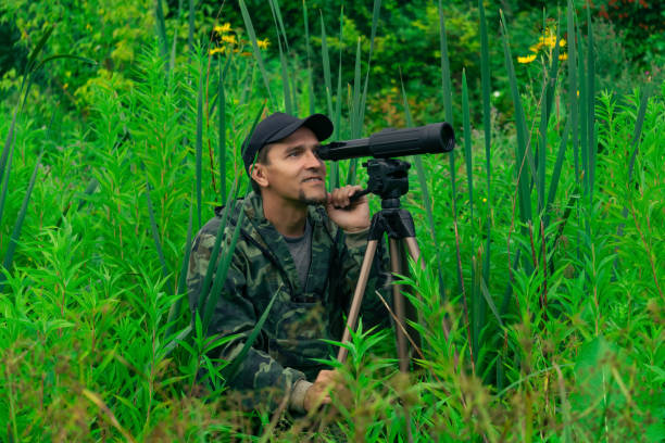 istock male explorer makes observations in the wild with a spotting scope 1340548976