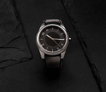 wrist watch with leather strap and on black background