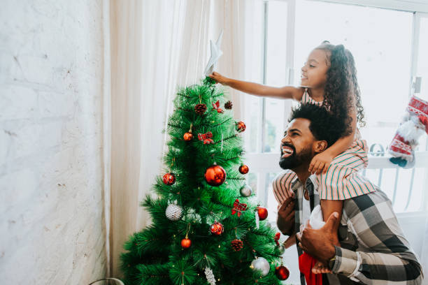 Father and daughter decorating Christmas tree