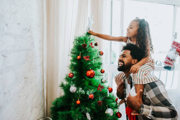 father and daughter decorating christmas tree - family christmas imagens e fotografias de stock