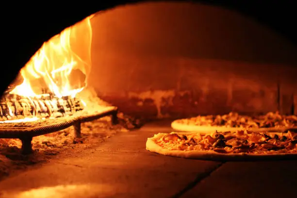 Photo of pizza in brick oven.