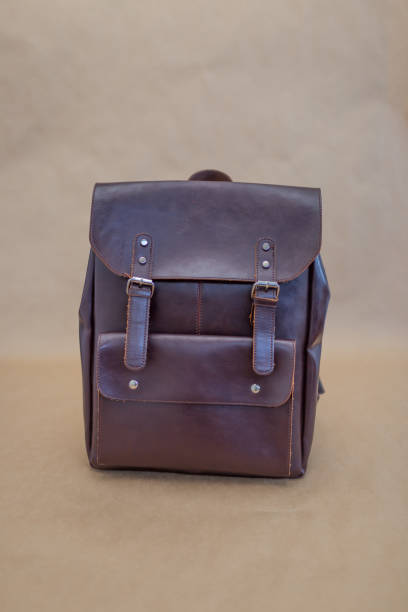 istock Brown leather backpacks isolated on beige background 1340552333