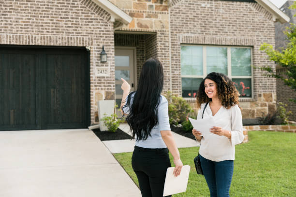 istock Unrecognizable real estate agent points to house while client listens 1340553911
