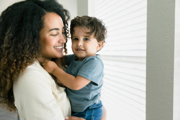 istock Mom smiles at son as he looks at camera 1340553950