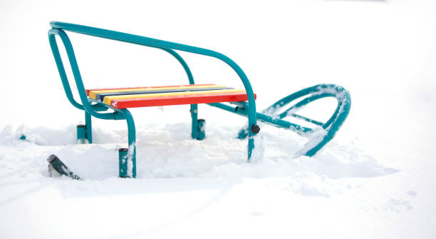 istock Colorful sleds on a white snowy background. 1340555868
