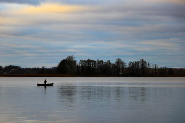 istock fisherman in a boat on the lake in the fall. 1340556035