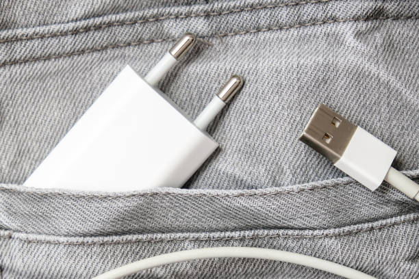 caricatore usb, filo e adattatore spina nella tasca grigia dei jeans, non dimenticare il caricabatterie a casa - mobile phone charging power plug adapter foto e immagini stock