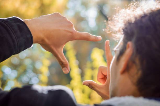 istock Young male student photographer found nice composition for a shot in bright autumn forest showing frame with his hands 1340560246