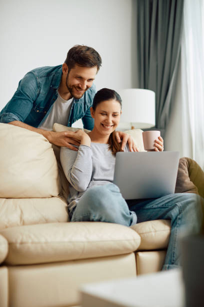 istock Young happy couple using laptop together at home. 1340560579