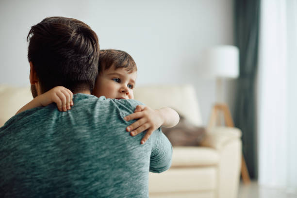 istock Affectionate little boy and his father embracing at home. 1340560640