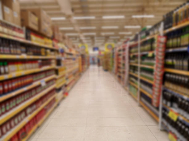 blurred aisle of supermarket with shelves. perspective of the abstract aisle of the supermarket. - department store shopping mall store inside of imagens e fotografias de stock