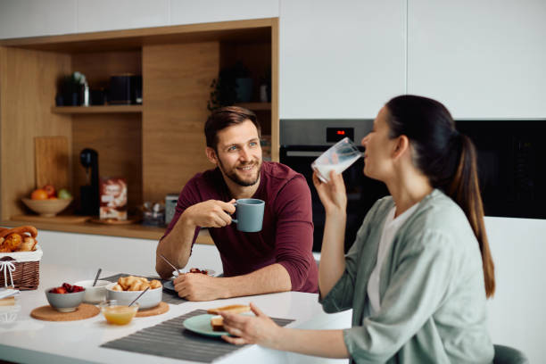 istock Happy couple talking to each other while having breakfast at dining table. 1340560891