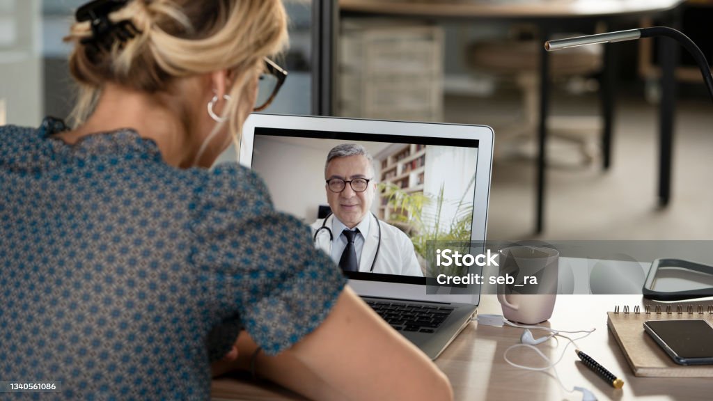Young woman talking with doctor on digital tablet Telemedicine Stock Photo