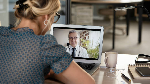 Young woman talking with doctor on digital tablet Young woman talking with doctor on digital tablet telemedicine stock pictures, royalty-free photos & images